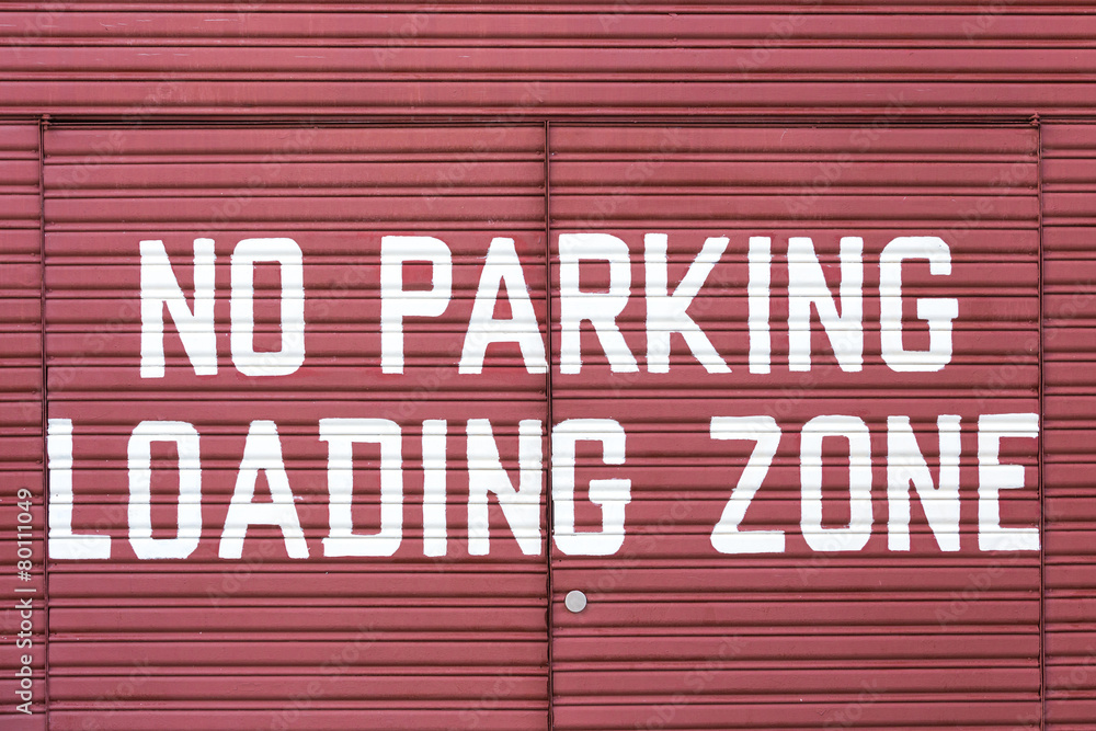 Word of No parking loading zone on metal red door
