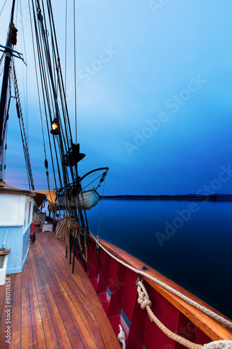 Sailboat at dawn with deep blue light. At sea.