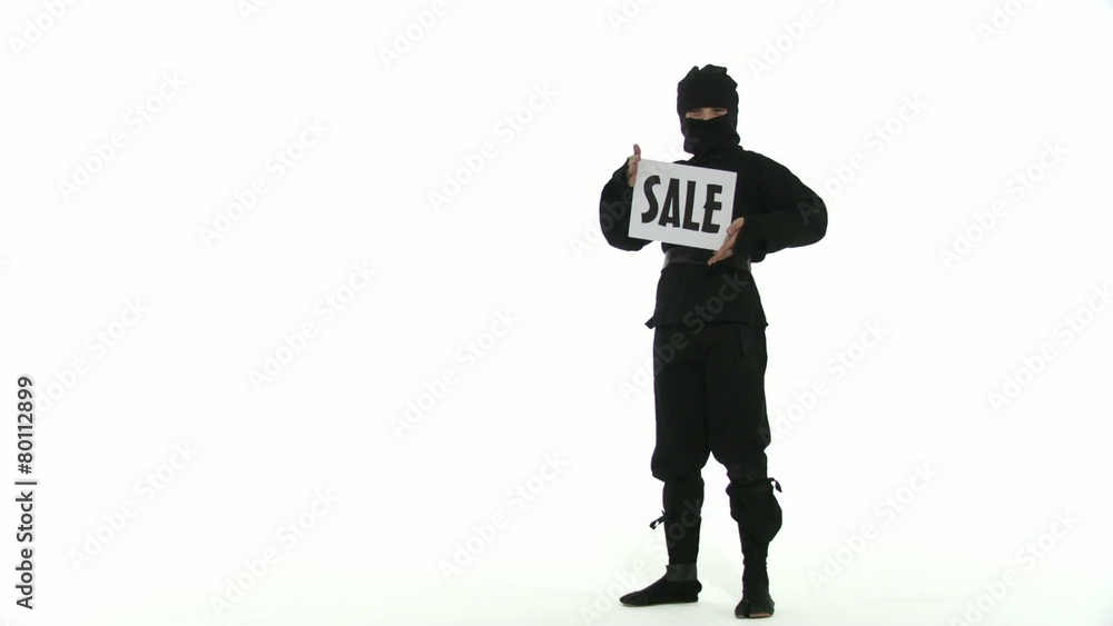 Young assassin holds up a SALE sign. Two clips against a white background. Young assassin holds up a SALE sign. Two clips against a white background.