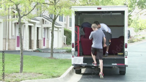 Two guys unload a moving van.  Disolves into timelapse sequence. photo