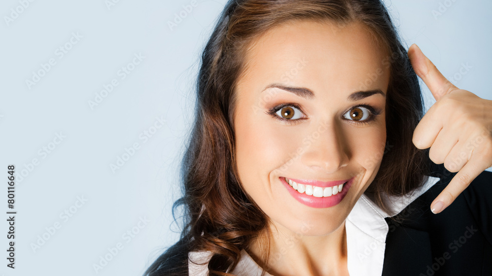 Businesswoman with call me gesture, on blue Businesswoman with call me gesture, on blue