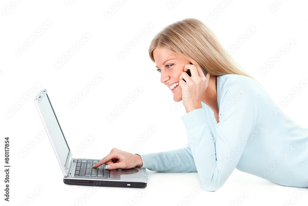 Blonde girl working on laptop and talking on phone Blonde girl working on laptop and talking on phone