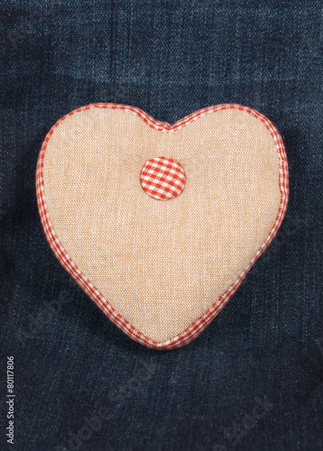 Fabric handmade heart on a blue denim jeans background