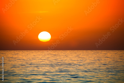 Fototapeta Naklejka Na Ścianę i Meble -  Uneven disk of the sun setting over the horizon