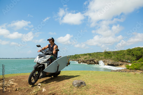 surfer man with surfboard and bike on the beach