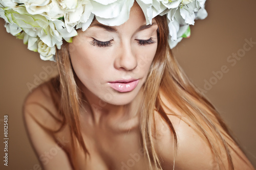 beautiful woman with flower on head, brown background
