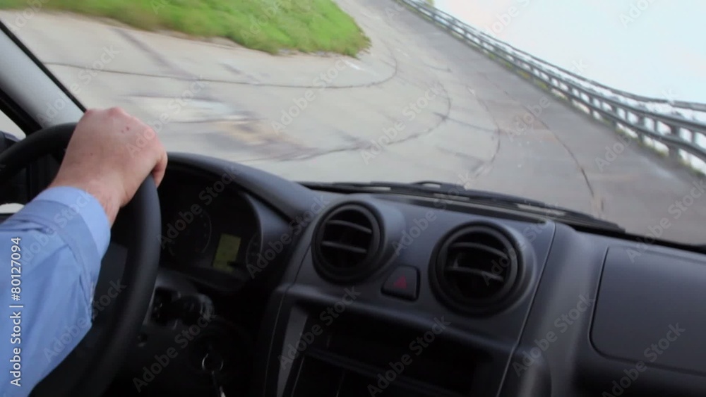 Hands hold car wheel during test drive, view from car Hands hold car wheel during test drive, view from car