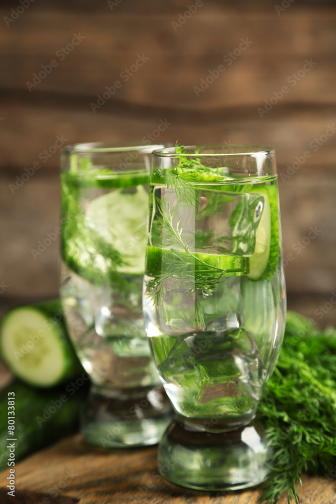 Glasses with fresh organic cucumber water on wooden table Glasses with fresh organic cucumber water on wooden table