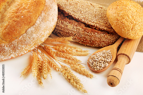 Fresh bread with wheat and wooden spoon of sunflower seeds