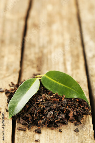 Black tea with leaf on old wooden table