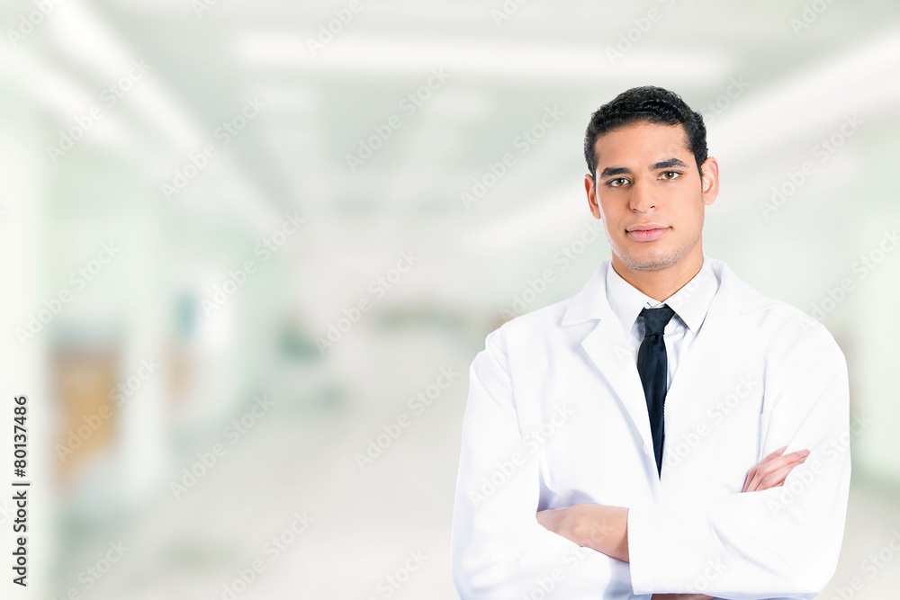 confident male doctor smiling arms folded standing in hospital confident male doctor smiling arms folded standing in hospital