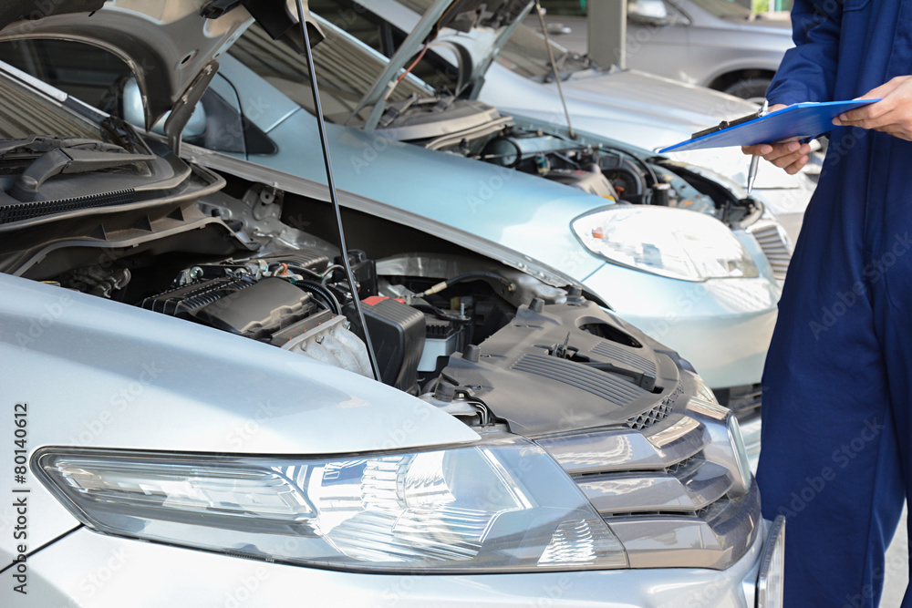 Auto mechanic (or technician) checking car engine Auto mechanic (or technician) checking car engine