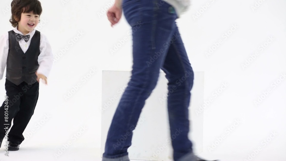Little cute boy and his mother run around large cube in studio Little cute boy and his mother run around large cube in studio