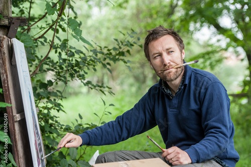 Quadro su tela Male artist on painting on canvas in outdoor.