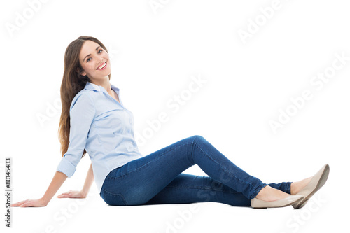 Young woman sitting on white background