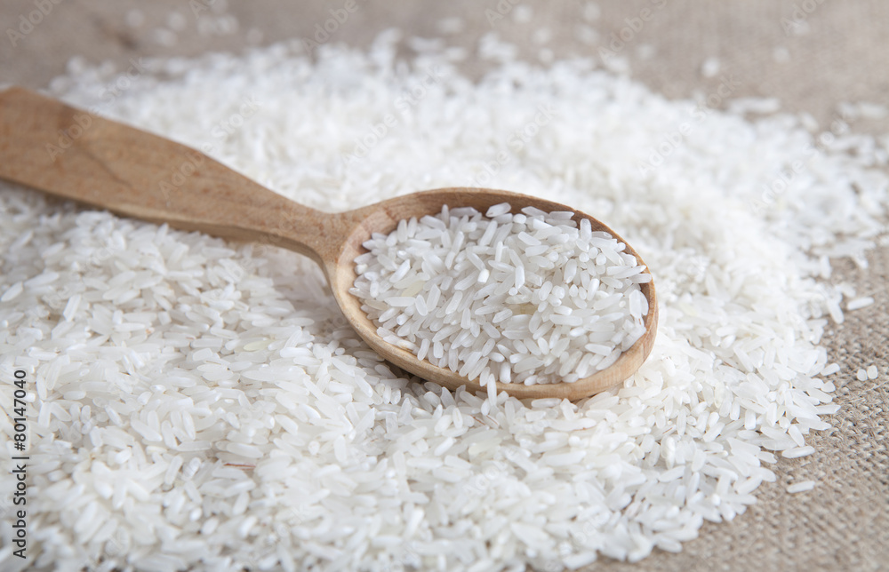close up of rice in a wooden spoon close up of rice in a wooden spoon