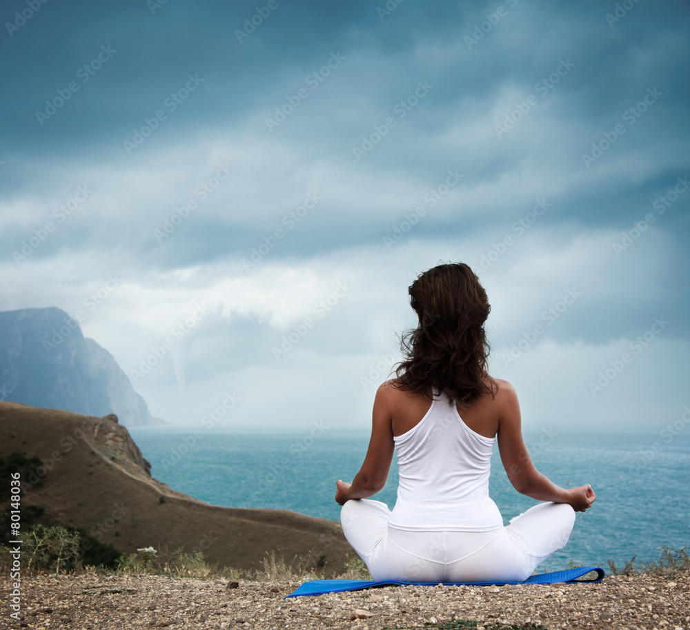 Woman Practicing Yoga at Stormy Sea