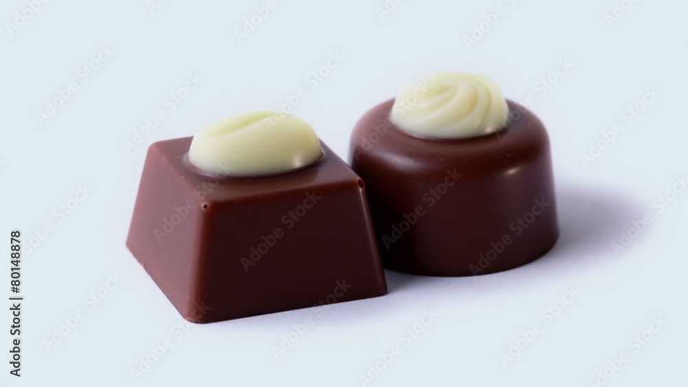 Two chocolate candies with icing circling, closeup Two chocolate candies with icing circling, closeup