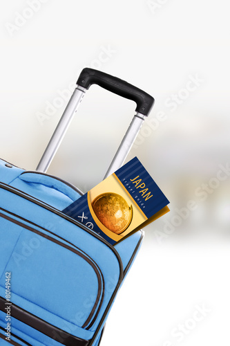 Japan. Blue suitcase with guidebook.