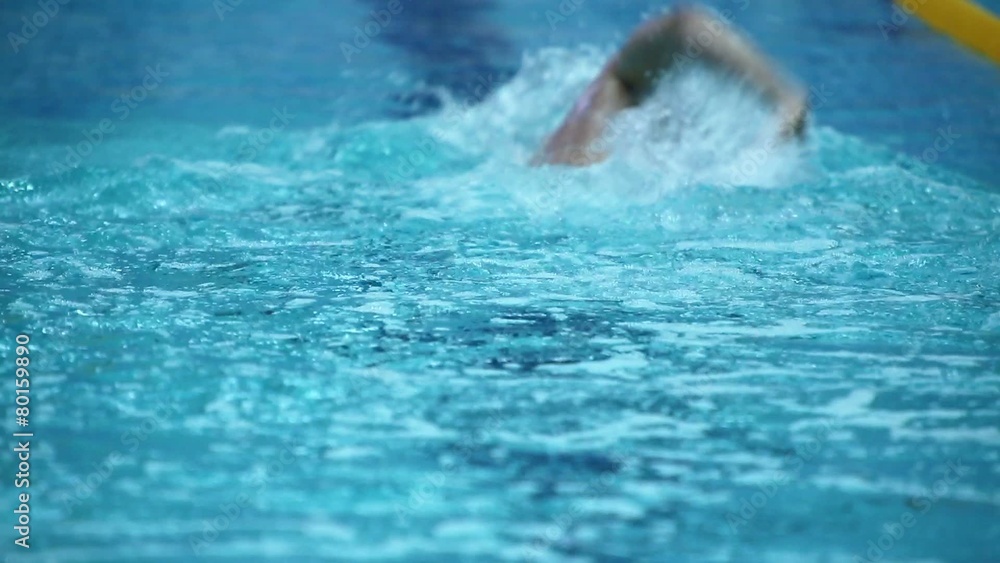 Sportsman swims away in crawl style by track at basin Sportsman swims away in crawl style by track at basin
