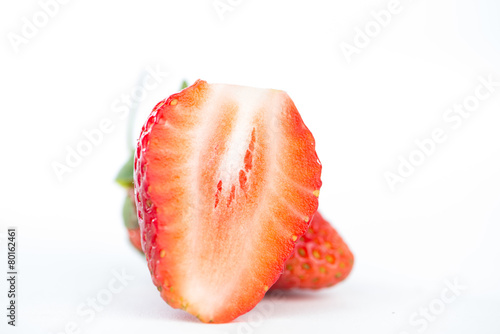 Closed up half of strawberry on white