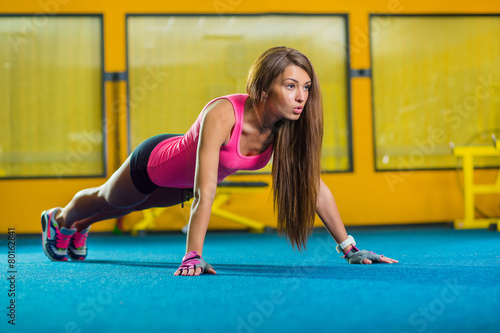 Gorgeous brunette warming up and doing some push ups a the gym