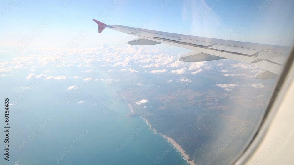 Wing of aircraft with trailing edge flaps and clouds Wing of aircraft with trailing edge flaps and clouds