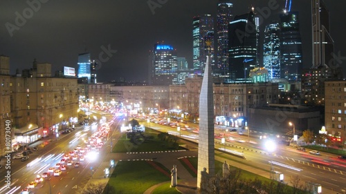 Night city: cars driving on main street seen from behind the Hero Monument, Moscow, Russia. Timelapse