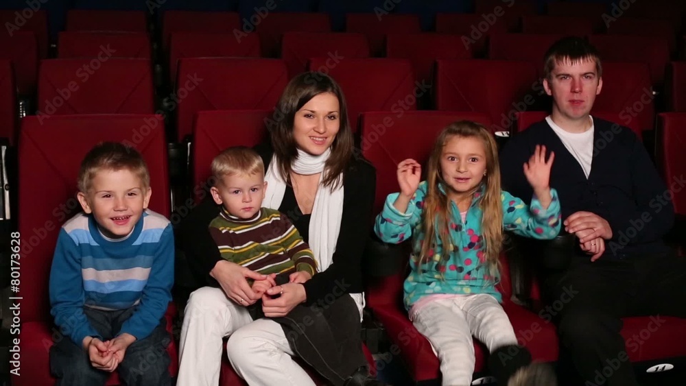 family sitting on the front row of auditorium at cinema family sitting on the front row of auditorium at cinema