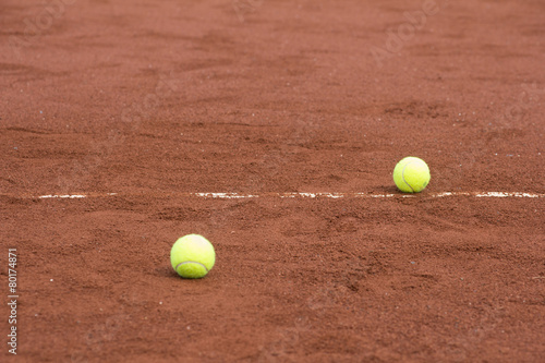 Two green tennis balls on the clay court © artemis_lady