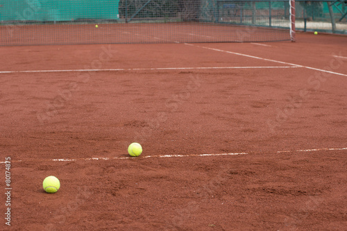 Two green tennis balls on the clay court © artemis_lady