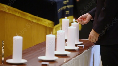 Man in suit set fire on candle by match at memorial ceremony photo