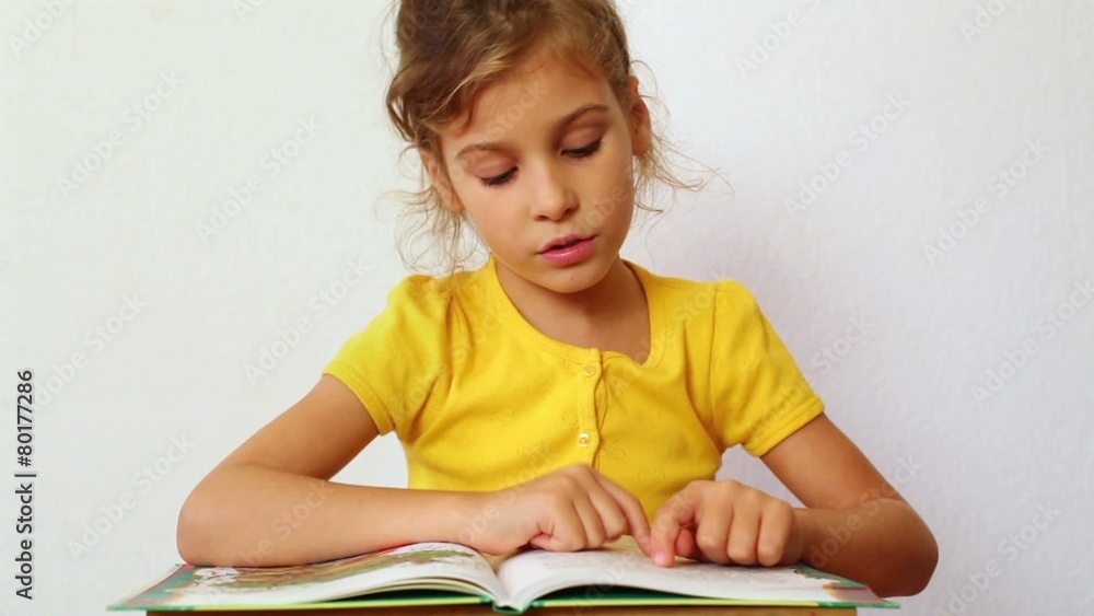 Little girl learns to read book, helping herself following lines Little girl learns to read book, helping herself following lines