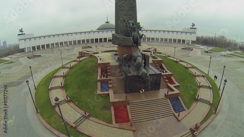 People walk near Monument with St.George piercing serpent photo