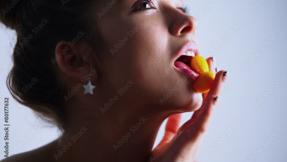 Beautiful young model bites fruit and poses, closeup Beautiful young model bites fruit and poses, closeup