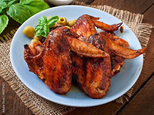 Plate of chicken wings on wooden background