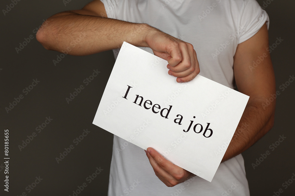 Sheet of paper with inscription I need a job in male hands