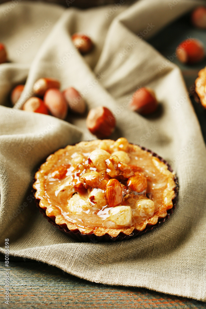 Mini cake with nuts on napkin on wooden background Mini cake with nuts on napkin on wooden background