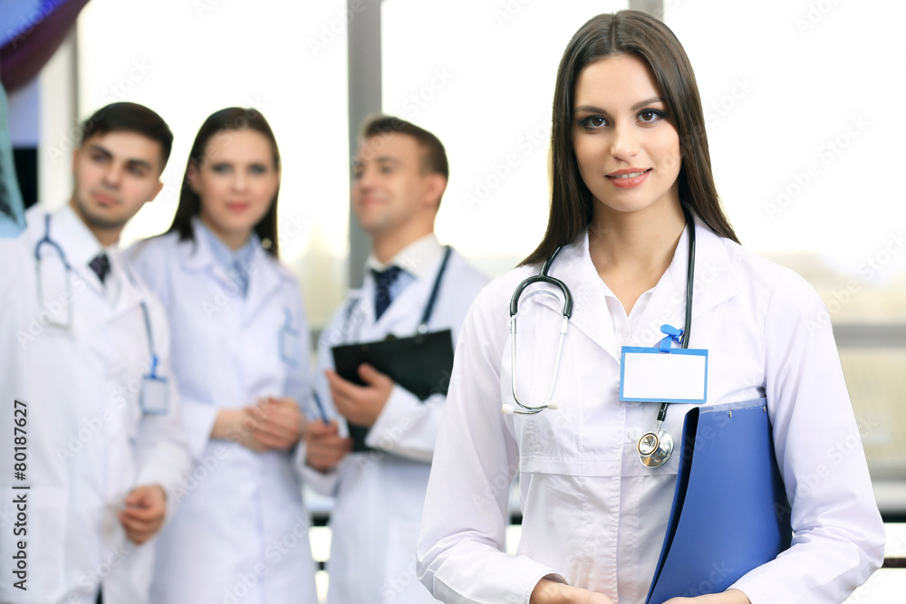 Beautiful young doctor with team in conference room