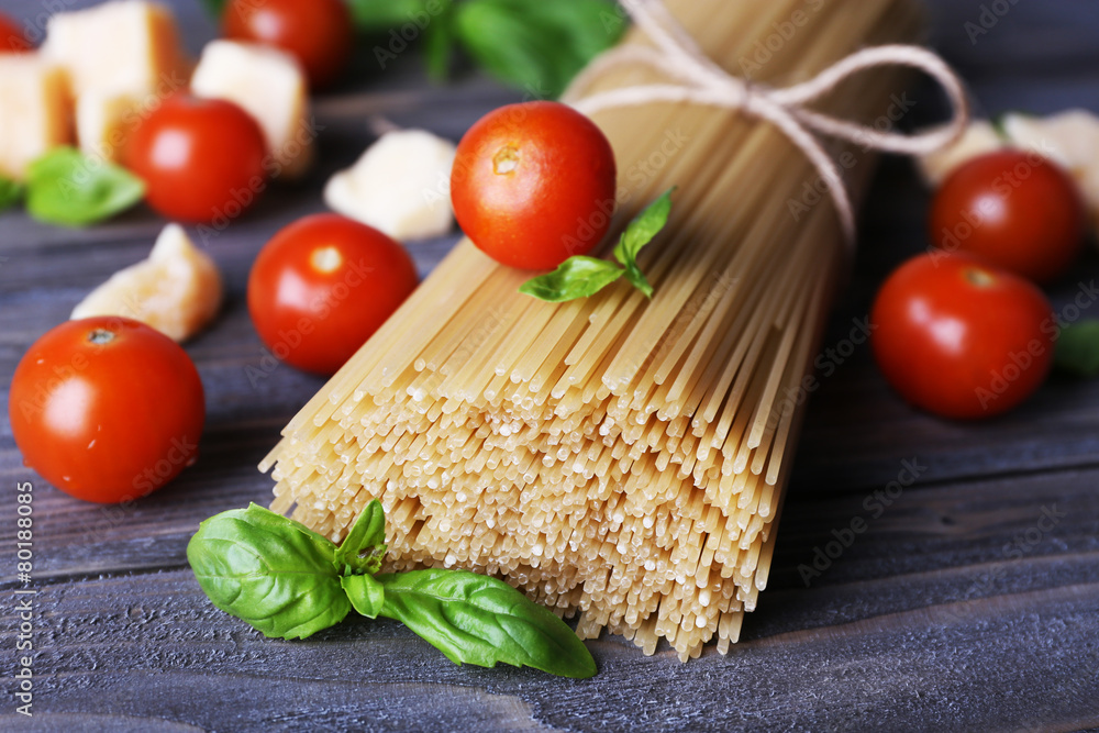 Raw pasta with tomatoes and cheese on wooden background Raw pasta with tomatoes and cheese on wooden background