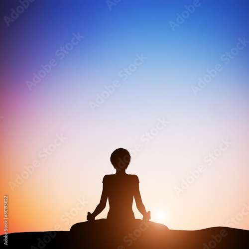 Woman in lotus yoga pose meditating at sunset. Zen