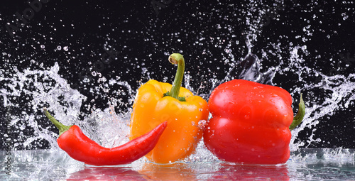 drops of water fall on the red and yellow pepper, splash