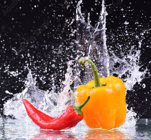 drops of water fall on the red and yellow pepper, splash photo