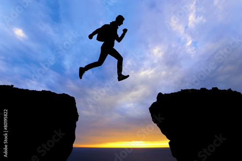 Running jumping man above sunset mountain. sport