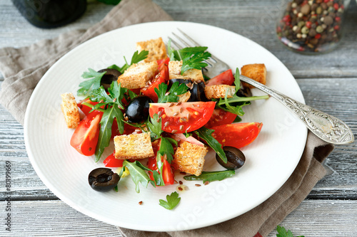 Delicious salad with olives, arugula and tomatoes