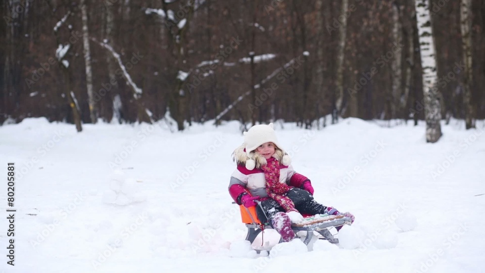 Father ride daughter on a sled through the wall of snow Father ride daughter on a sled through the wall of snow