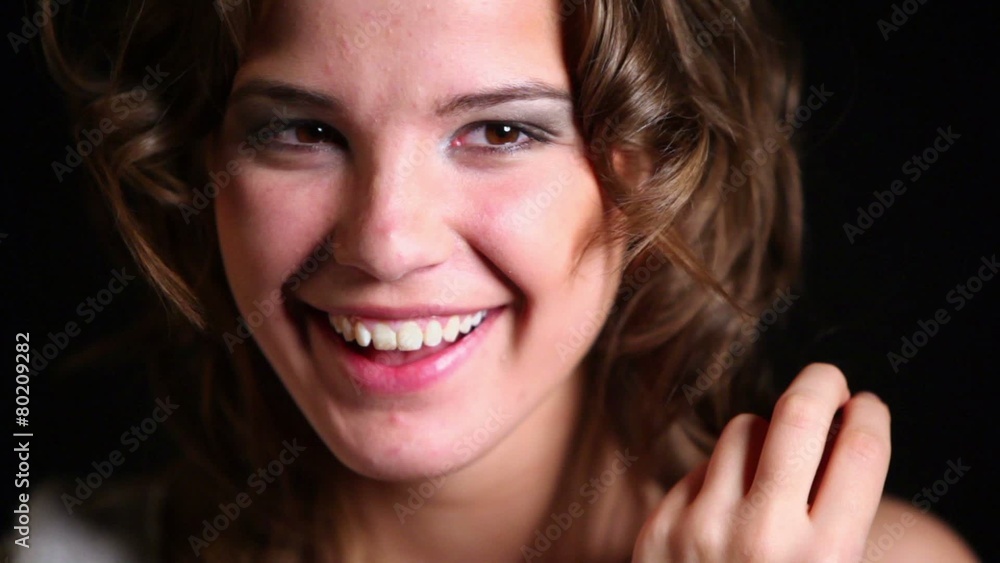 Young girl spins her long hair and laughs, close-up Young girl spins her long hair and laughs, close-up