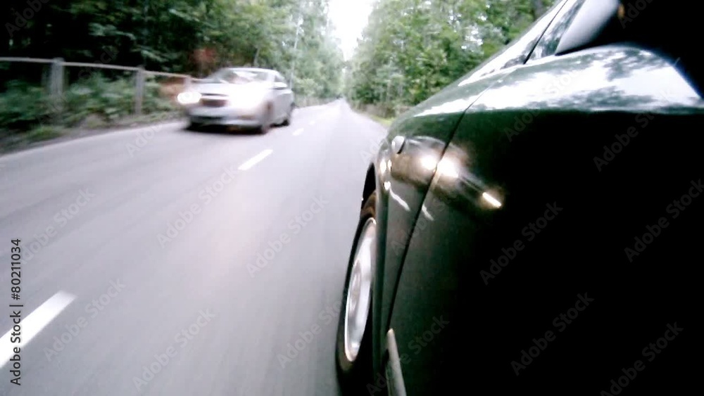 Car goes on asphalt road near trees in wood Car goes on asphalt road near trees in wood