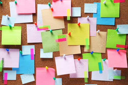 Image of colorful sticky notes on cork bulletin board photo