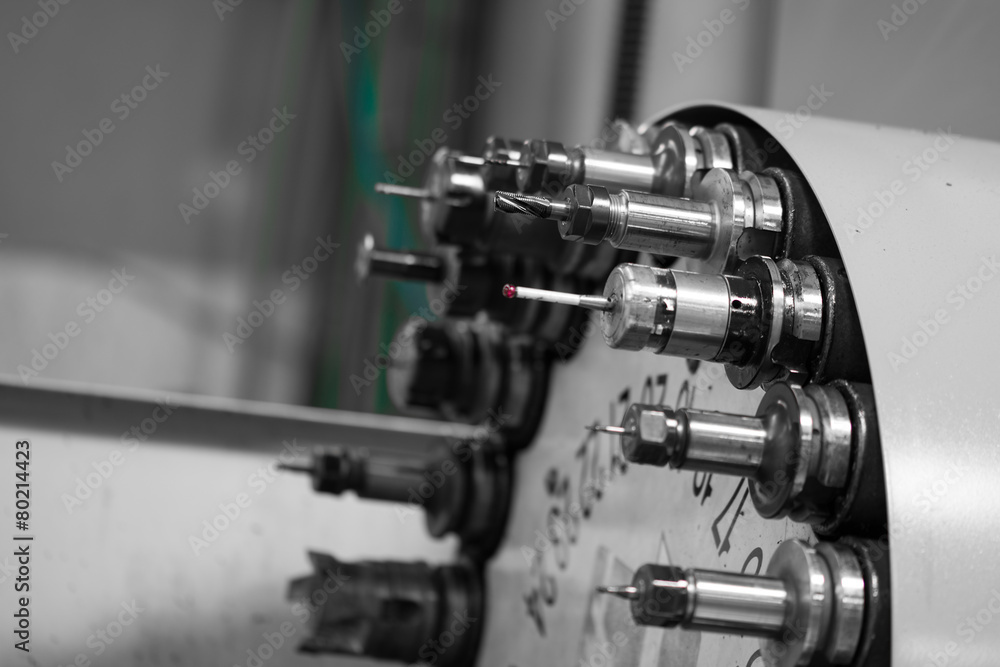 Naklejka premium Rotating head with tools at CNC lathe in workshop